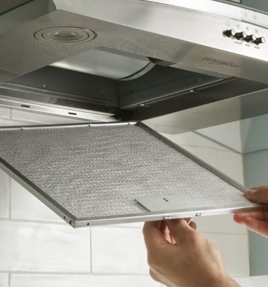 A person interacts with a stainless steel oven door, highlighting appliance repair services in San Antonio, TX.